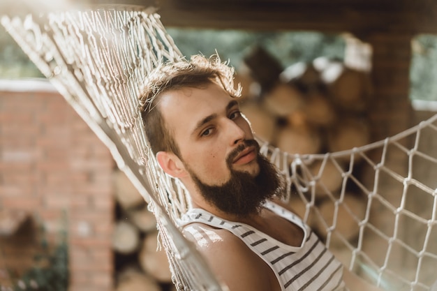 bearded man lying hammock on a warm summer day