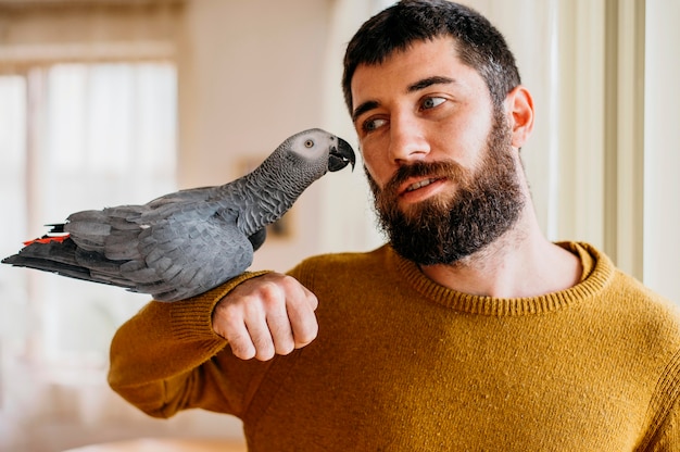 Bearded man petting cute bird