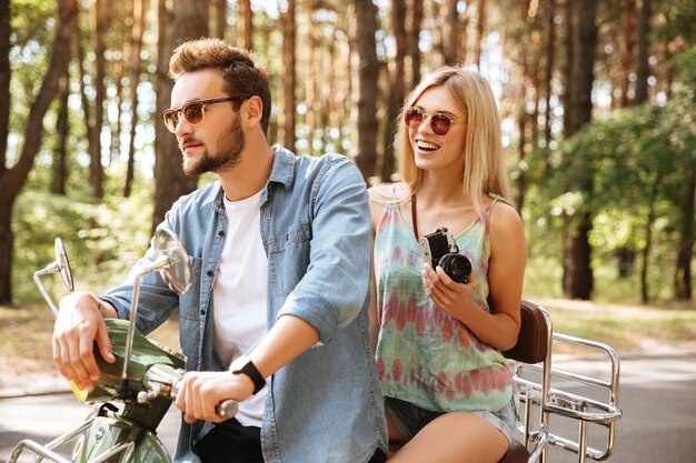 Bearded man on scooter with womanfriend outdoors