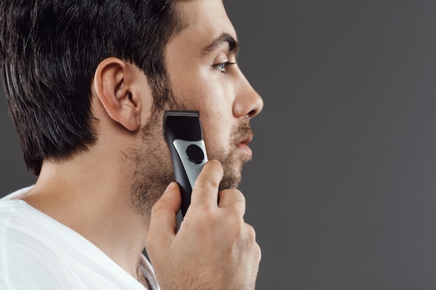 Bearded man shaving beard, getting ready