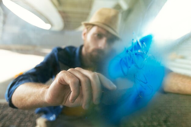 Bearded man working with spray paint