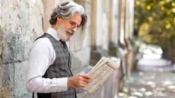 Free photo bearded mature male reading newspaper