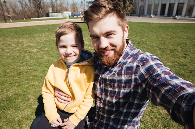 Free Photo bearded smiling father outdoors with his little son