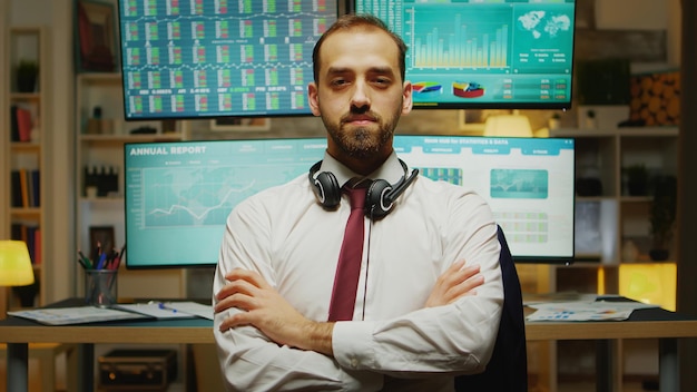 Free photo bearded stock market trader looking at the camera with hands crossed.