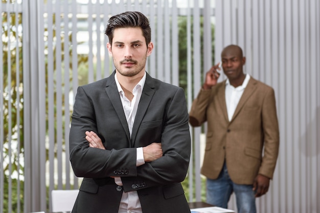 Bearded worker and crossed arms at the office