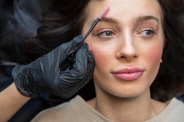 Beautician doing an eyebrow treatment for her client