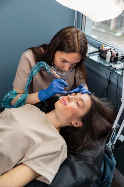 Beautician doing an eyebrow treatment for her female client