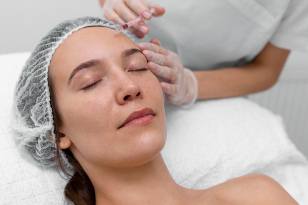 Beautician doing injection filler on female client