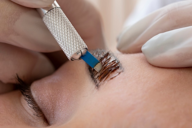 Beautician doing a microblading procedure on a client's eyebrows