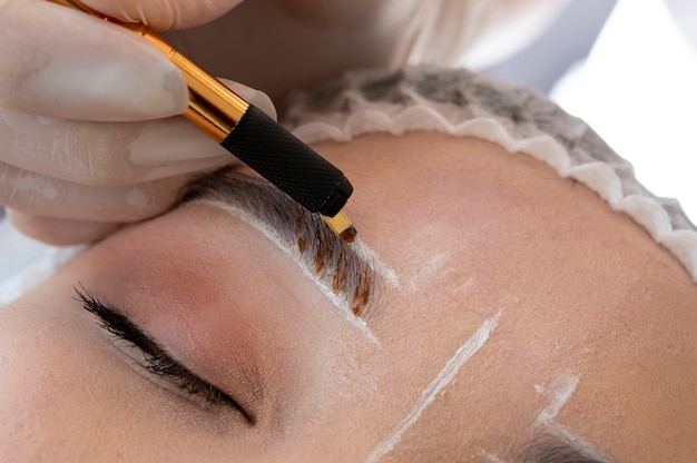 Free Photo beautician doing a microblading procedure on a client's eyebrows