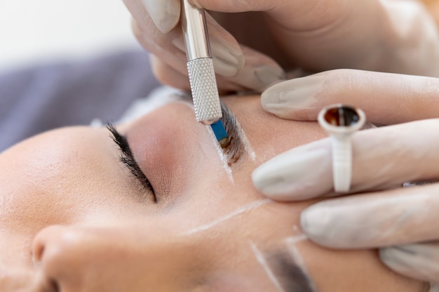 Free photo beautician doing a microblading procedure on a client's eyebrows