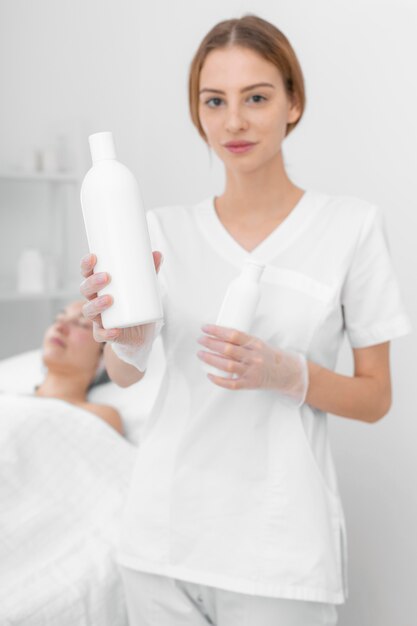 Beautician with lotion for female client