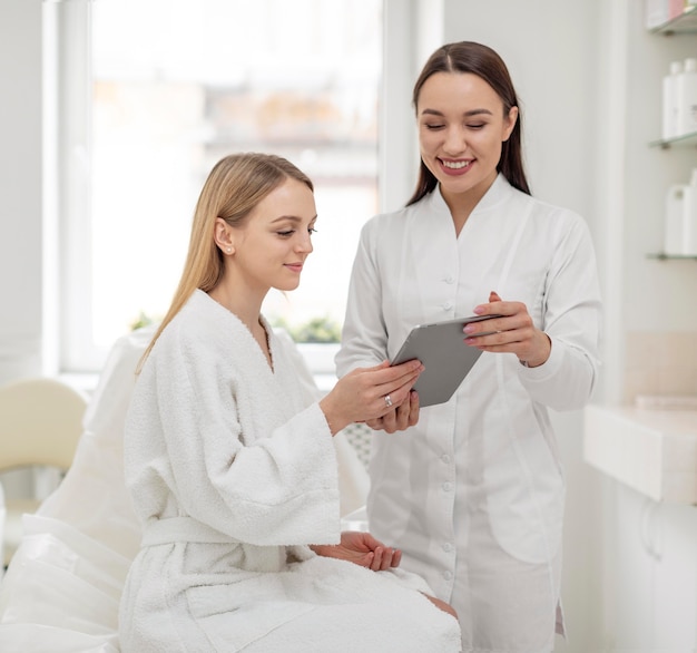 Beautician woman at clinic consults client