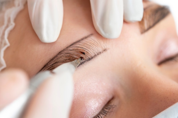 Beautician working on a client's eyebrows