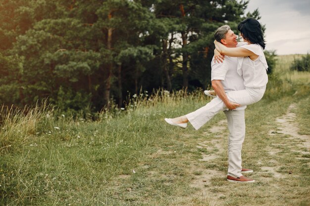 Beautiful adult couple spends time in a summer field