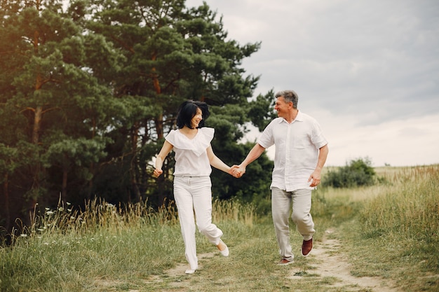 Beautiful adult couple spends time in a summer field