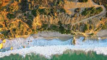 Free photo beautiful aerial photography of the shoreline of the sea with amazing waves on a sunny day