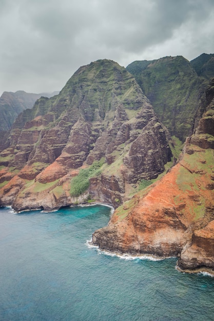 Beautiful aerial shot of the coast of Napali with clear beautiful water and steep rocks