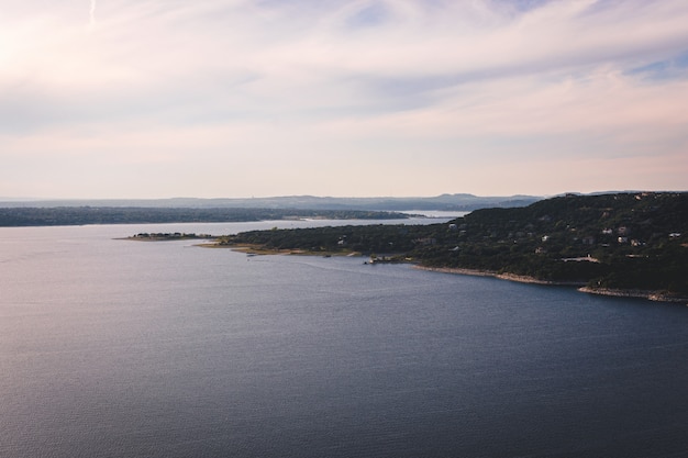 Free photo beautiful aerial shot of a lake with a green field on the side