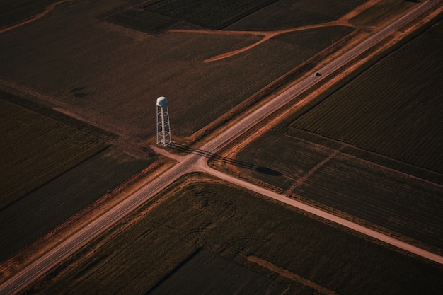 Free photo beautiful aerial shot of narrow roads intersection in the countryside with a white tower