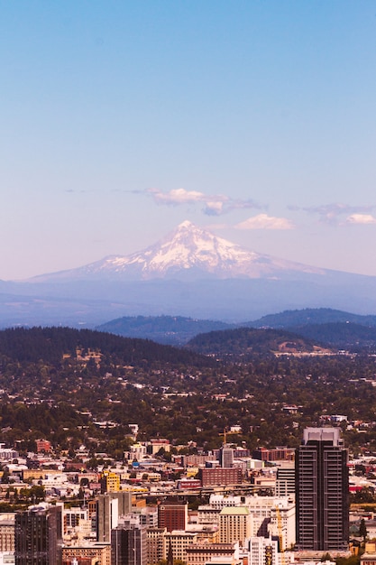 Beautiful aerial shot of an urban city with an amazing snowy mountain