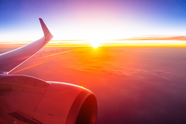 Beautiful aerial view from airplane wing on white cloud and sky at sunset time