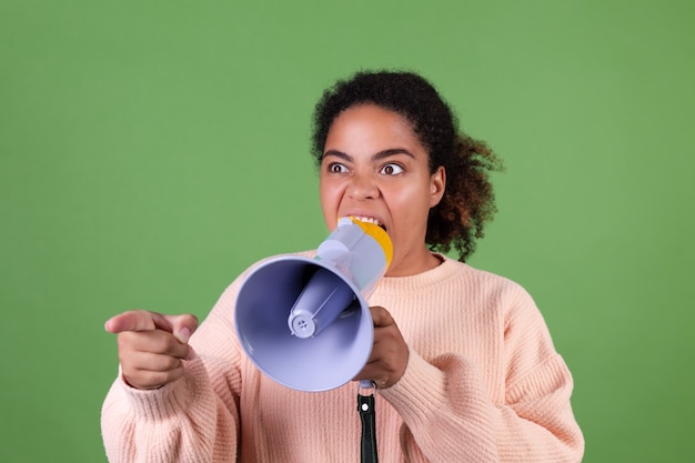 Free photo beautiful african american woman on green wall screaming shouting  in megaphone ask attention