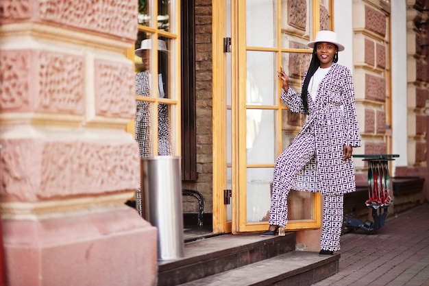 Free Photo beautiful african american woman natural makeup wear fashion clothes casual black and white dress code office style total blouse and pants suit and hat