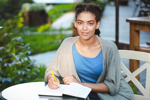 Beautiful african girl  writing at the notebook