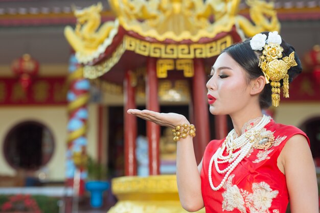 A beautiful asian girl wearing a red suit 