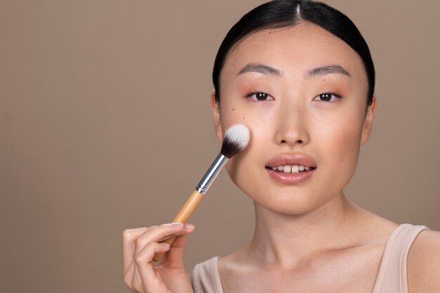 Beautiful asian woman applying makeup