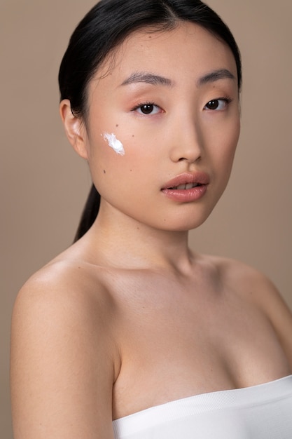 Beautiful asian woman applying skin treatment