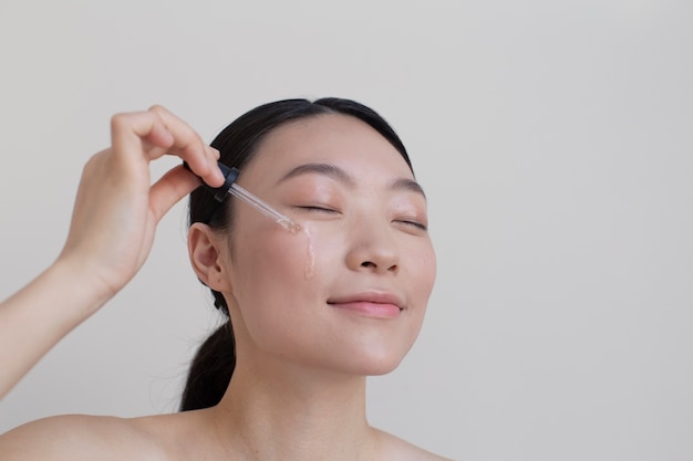 Beautiful asian woman posing with facial cream