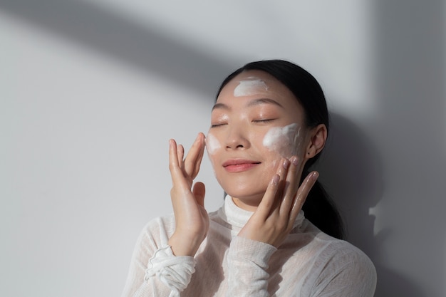 Beautiful asian woman posing with facial cream