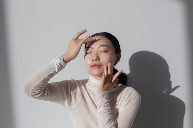 Beautiful asian woman posing with facial cream