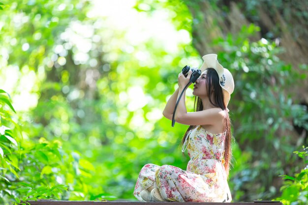 beautiful asian woman taking photo in the park