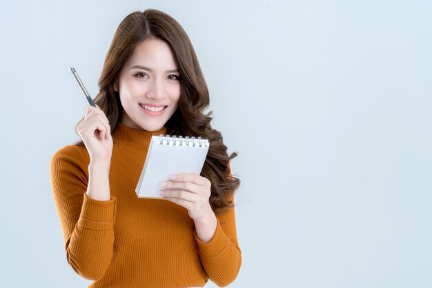 Beautiful asian woman write down note in paper with happiness and joyful moment isolate white background