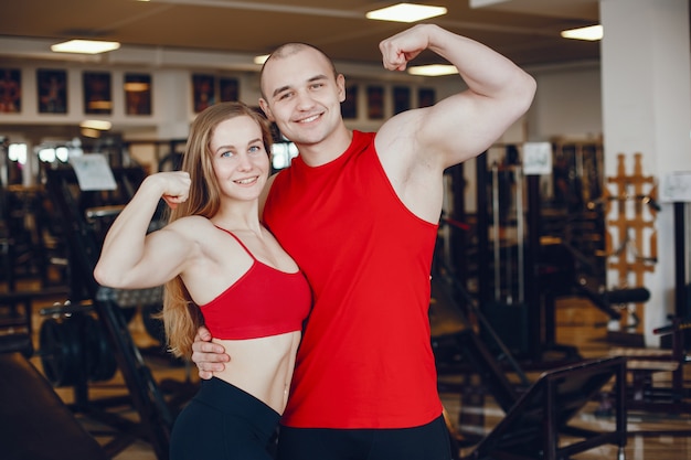 A beautiful and athletic sportswear girl training in the gym with friend