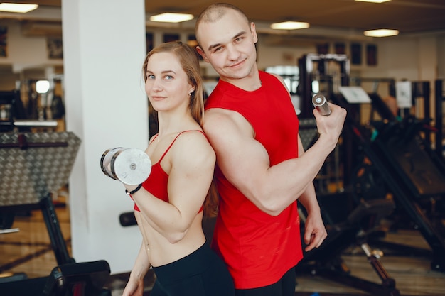 A beautiful and athletic sportswear girl training in the gym with friend