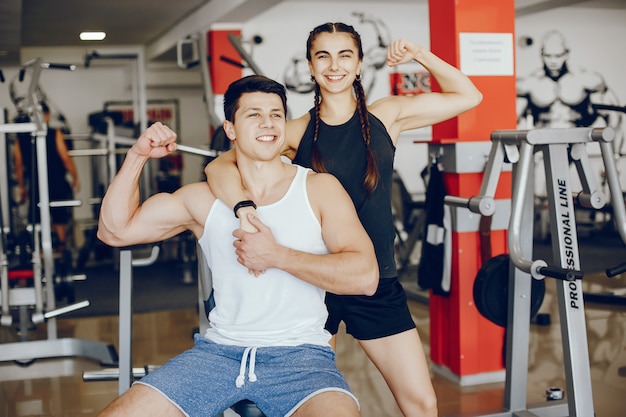 A beautiful and athletic sportswear girl training in the gym with her boyfriend