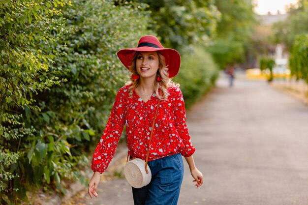 Beautiful attractive stylish blond smiling woman in straw red hat and blouse summer fashion outfit