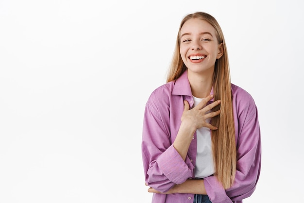 Beautiful authentic girl laughing smiling white teeth and looking happy joking and having fun standing against white background