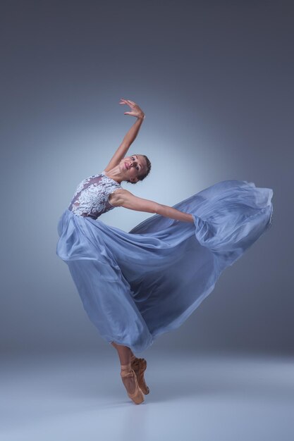 The beautiful ballerina dancing in blue long dress