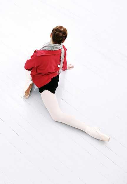 Free photo beautiful ballerina make stretching on the floor