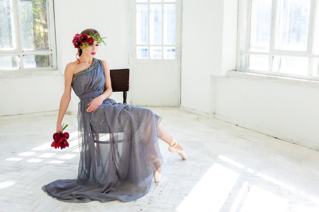 beautiful ballerina sitting in long gray dress