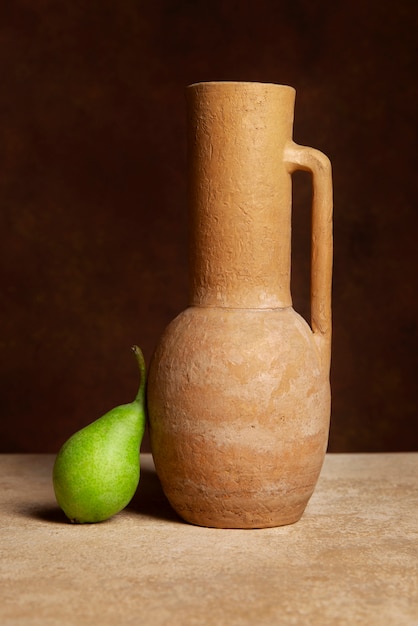 Free photo beautiful baroque vase and pear still life