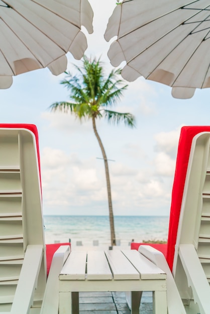 Free photo beautiful beach chairs with umbrella around outdoor swimming poo