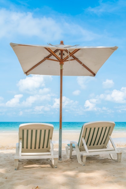 Beautiful beach chairs with umbrella on tropical white sand beac