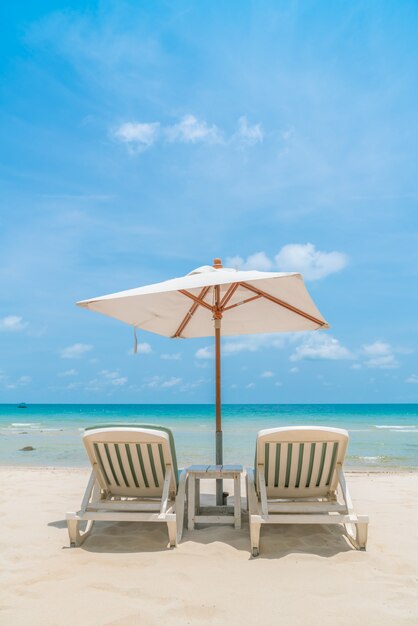 Beautiful beach chairs with umbrella on tropical white sand beac