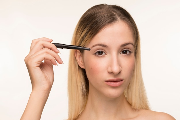 Free Photo beautiful blonde girl holding eyeliner